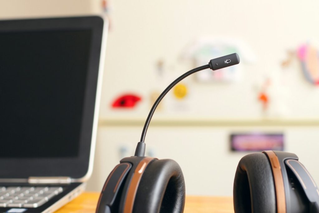 Black and brown headset with laptop in the background