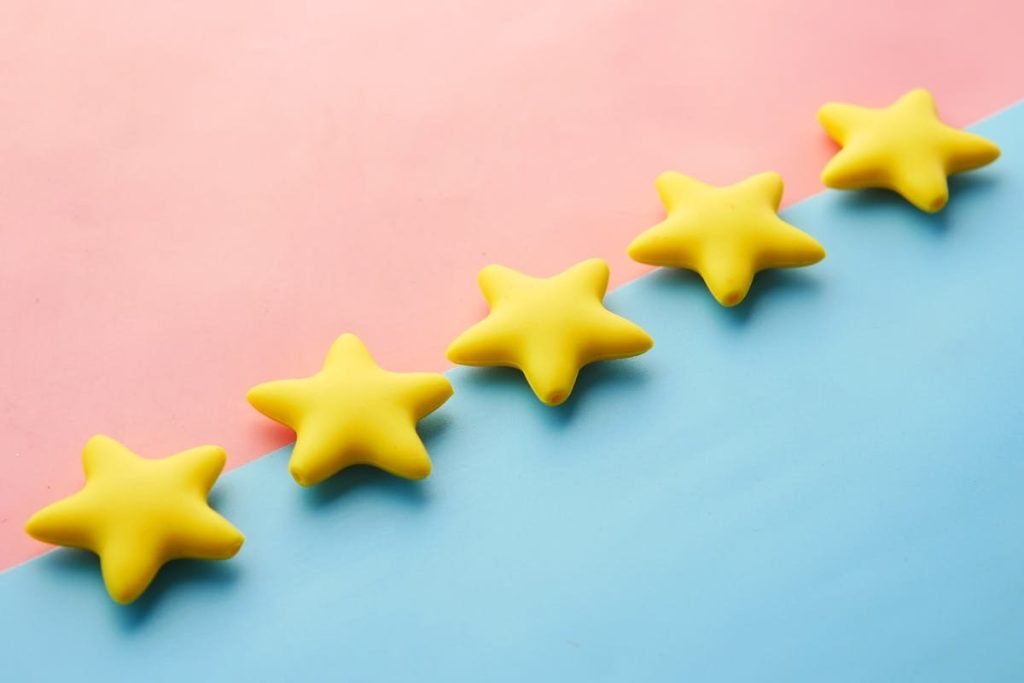 Five stars on a soft blue and pink background
